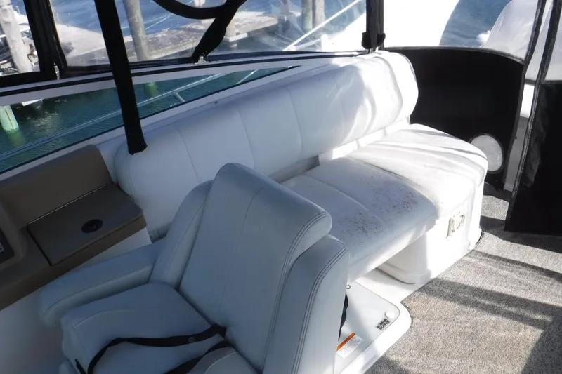 Slide: The Image of 2001 Carver 350 Mariner interior with white seating and helm, dockside view. - 5