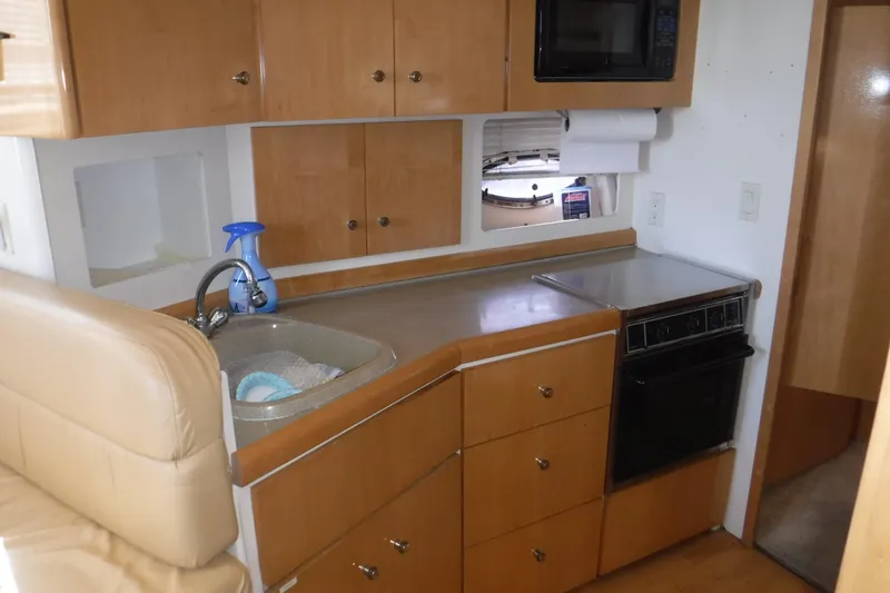 Slide: The Image of 2001 Carver 350 Mariner kitchen with wooden cabinets, sink, and appliances. - 8
