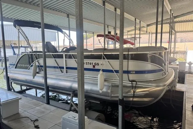 The Image of 2022 Berkshire 250CL STS pontoon boat docked under a covered marina. - 0