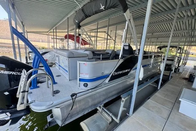 Slide: The Image of 2022 Berkshire 250CL STS pontoon boat docked under a covered marina. - 2