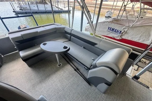 Slide: The Image of 2022 Berkshire 250CL STS pontoon boat interior with gray seating and round table. - 22