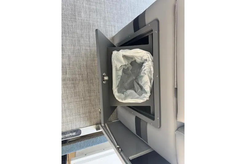 Slide: The Image of Interior storage compartment with trash bin in 2022 Berkshire 250CL STS boat. - 28