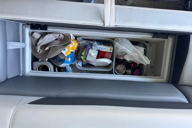 Slide: The Image of Storage compartment in a 2022 Berkshire 250CL STS boat, filled with various items. - 29