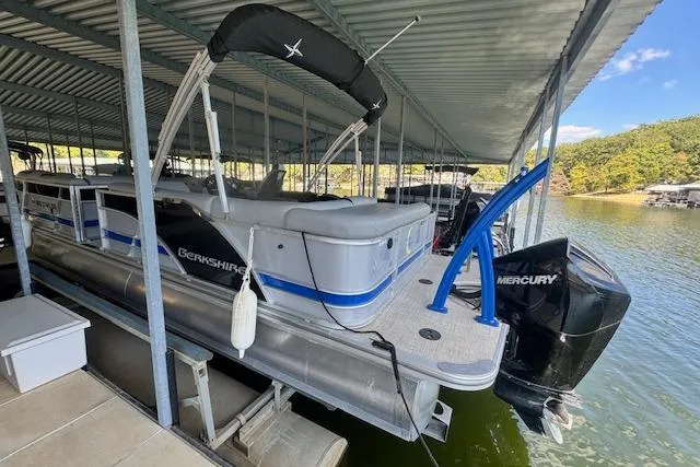 Slide: The Image of 2022 Berkshire 250CL STS pontoon boat docked under a covered marina. - 3