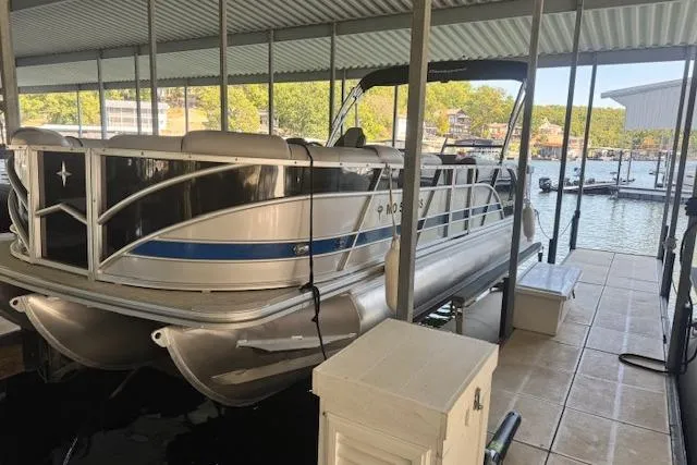 Slide: The Image of 2022 Berkshire 250CL STS pontoon boat docked in a covered marina. - 5