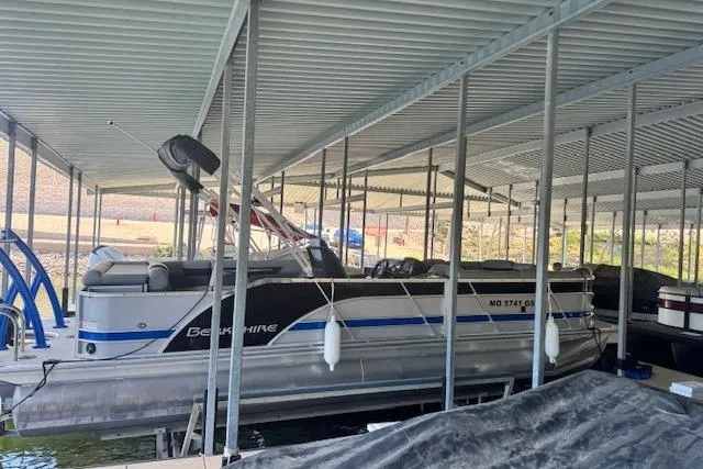 Slide: The Image of 2022 Berkshire 250CL STS pontoon boat docked under covered marina. - 8