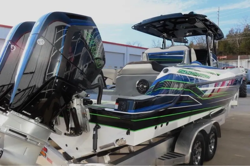 Slide: The Image of 2025 Sunsation 32 CCX boat with vibrant graphics on a trailer, featuring powerful outboard engines. - 5