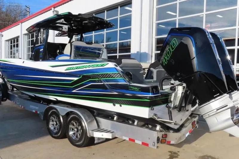 Slide: The Image of 2025 Sunsation 32 CCX boat with vibrant blue and green design on a trailer. - 6