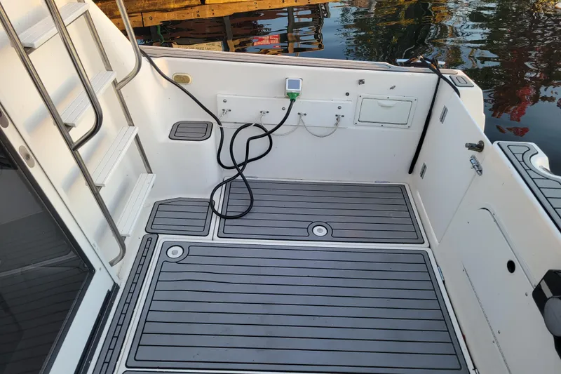 Slide: The Image of 1998 Bayliner 2858 Ciera Command Bridge boat deck with ladder and water reflections. - 10