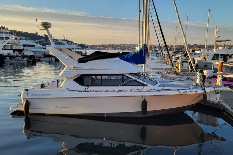Slide: The Image of 1998 Bayliner 2858 Ciera Command Bridge docked at marina during sunset. - 2