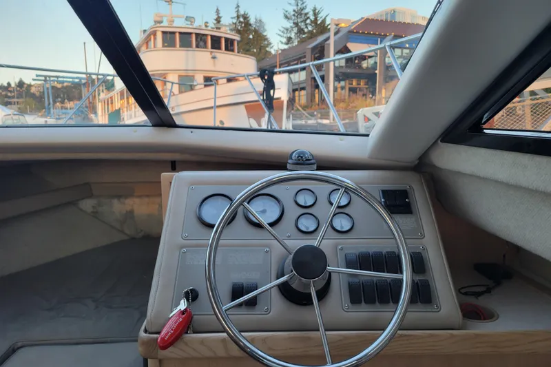Slide: The Image of 1998 Bayliner 2858 Ciera Command Bridge helm with steering wheel and gauges, docked at marina. - 20