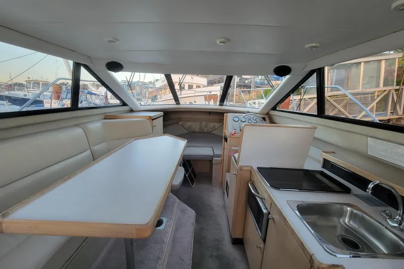 Slide: The Image of Interior of 1998 Bayliner 2858 Ciera Command Bridge with seating, table, and kitchenette. - 28