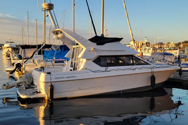 Slide: The Image of 1998 Bayliner 2858 Ciera Command Bridge docked at marina during sunset. - 3