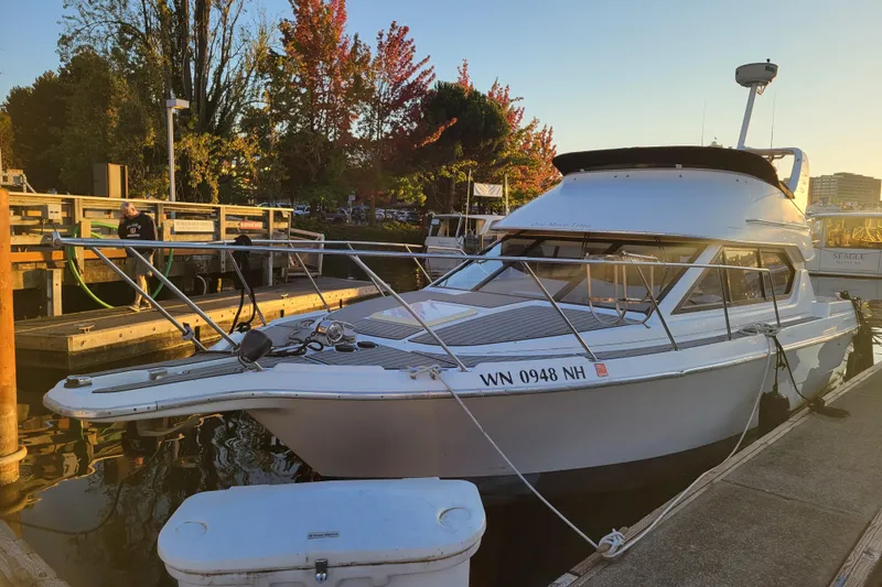 Slide: The Image of 1998 Bayliner 2858 Ciera Command Bridge docked at sunset, surrounded by autumn trees. - 4