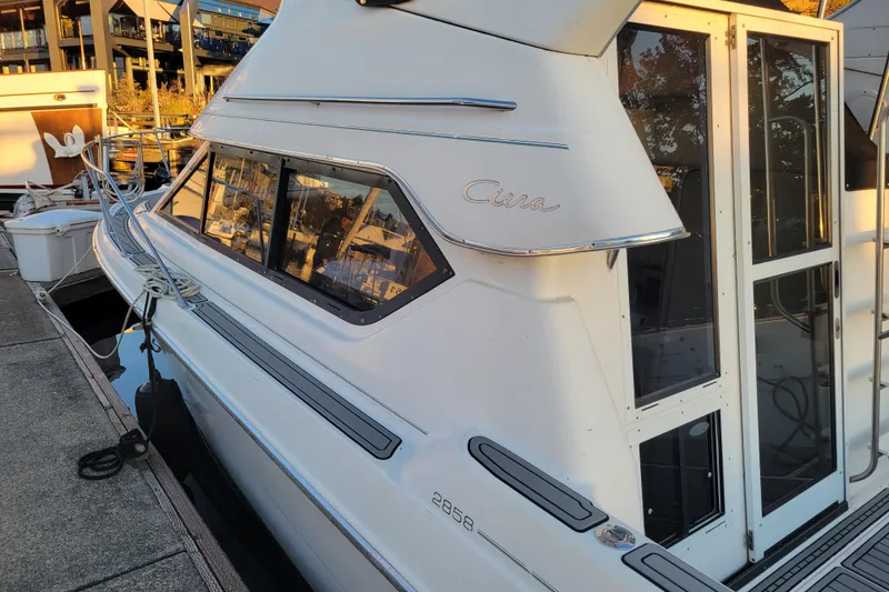 Slide: The Image of 1998 Bayliner 2858 Ciera Command Bridge docked, showcasing sleek design and windows. - 5