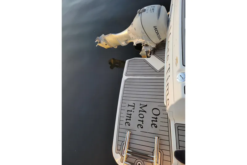 Slide: The Image of 1998 Bayliner 2858 Ciera Command Bridge with Honda outboard motor, docked on calm water. - 7