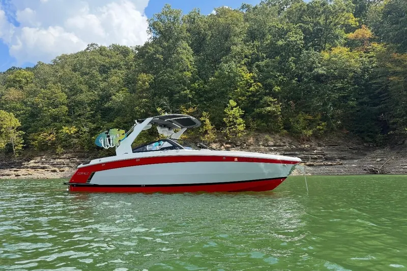 Slide: The Image of 2021 Cobalt R8 Surf boat in red and white on a trailer, parked outdoors. - 4