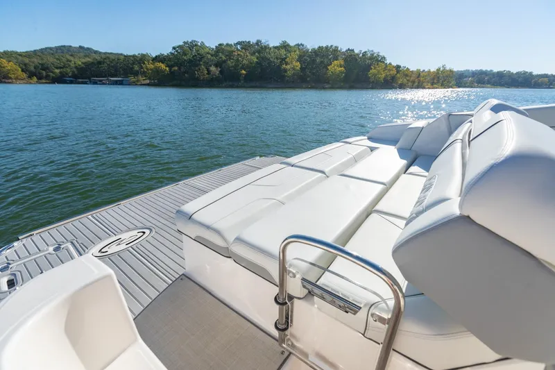 Slide: The Image of 2023 Regal LS36 boat with luxurious seating on a serene lake. - 11