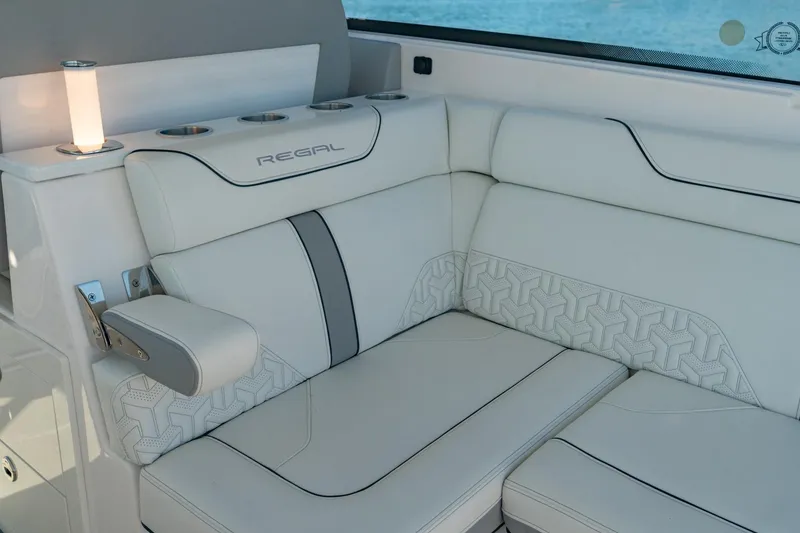 Slide: The Image of Luxurious seating on 2023 Regal LS36 boat with elegant white upholstery and cup holders. - 16