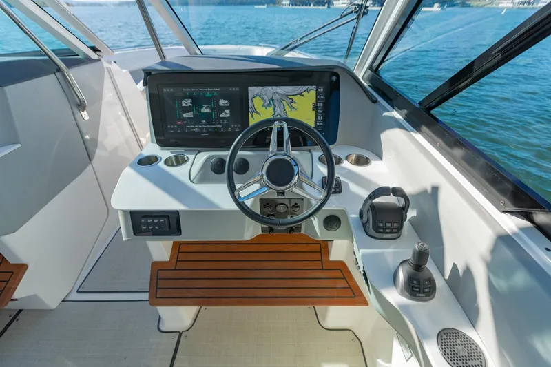 Slide: The Image of 2023 Regal LS36 boat helm with modern controls and navigation display on open water. - 25