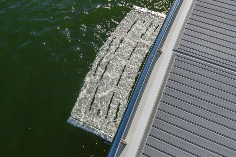 Slide: The Image of 2023 Regal LS36 boat swim platform with water flow, docked on a sunny day. - 9