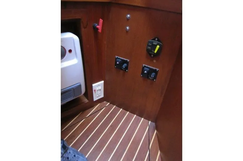 Slide: The Image of 1983 Nauticat 43 interior control panel with wooden finish and electrical switches. - 19