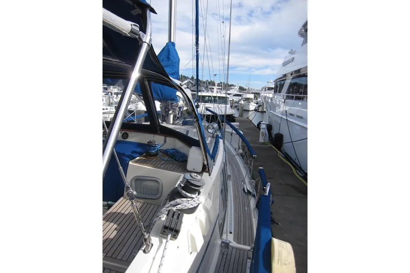 Slide: The Image of 1983 Nauticat 43 sailboat docked at marina, showcasing deck and rigging. - 33