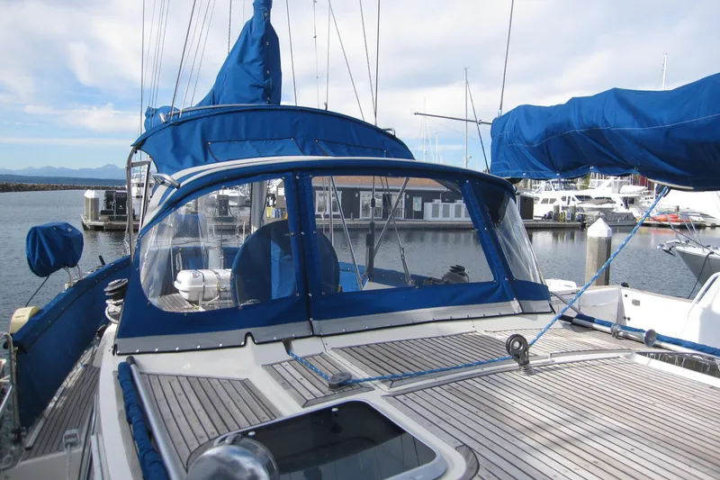Slide: The Image of 1983 Nauticat 43 sailboat with blue covers docked at a marina. - 36