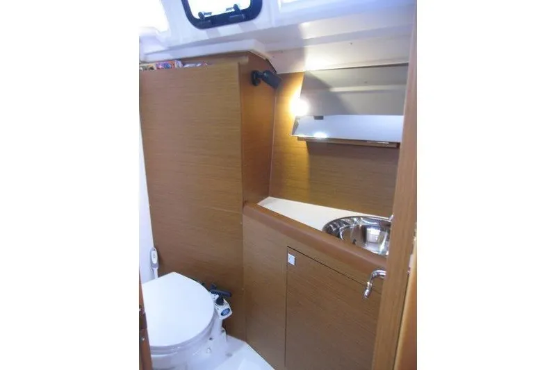 Slide: The Image of 2022 Jeanneau Sun Odyssey 349 yacht bathroom with wooden cabinetry and stainless steel sink. - 17