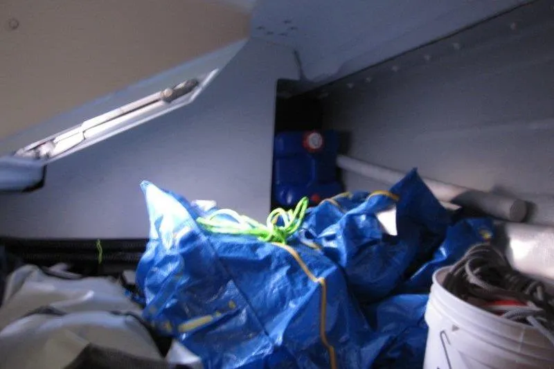 Slide: The Image of Interior storage area of 2022 Jeanneau Sun Odyssey 349 sailboat with blue tarp and equipment. - 21