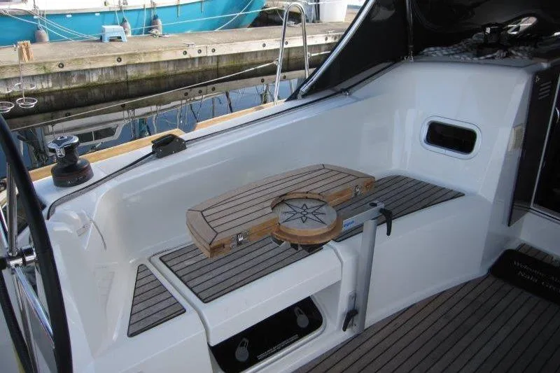 Slide: The Image of 2022 Jeanneau Sun Odyssey 349 cockpit with wooden seating and nautical-themed table. - 31