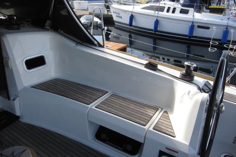 Slide: The Image of 2022 Jeanneau Sun Odyssey 349 cockpit with seating and steering wheel, docked at marina. - 32