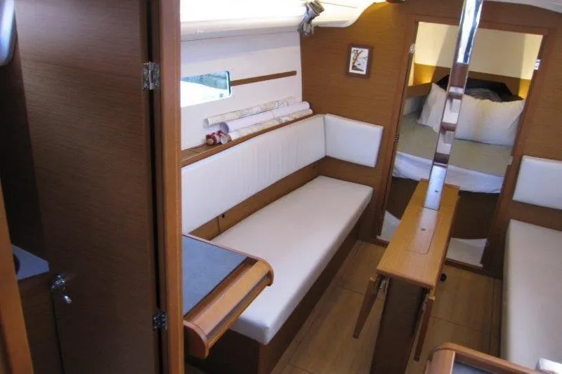 Slide: The Image of Interior of 2022 Jeanneau Sun Odyssey 349 sailboat, featuring cozy seating and wooden finishes. - 4