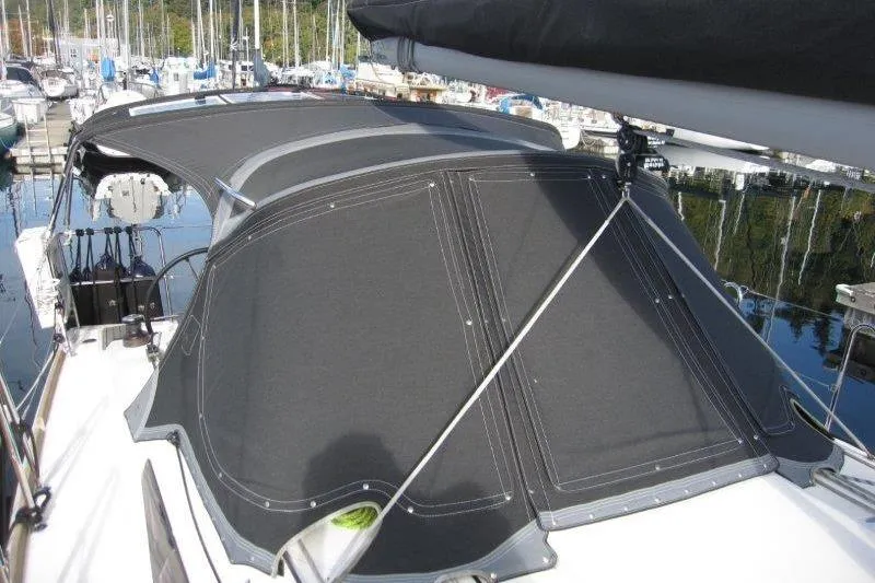 Slide: The Image of 2022 Jeanneau Sun Odyssey 349 sailboat with black canvas cover in marina. - 43