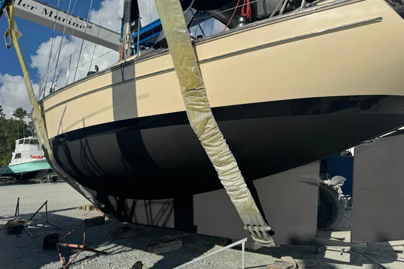 Slide: The Image of Island Packet 380 sailboat from 2000 in dry dock, hull visible, sunny day. - 10