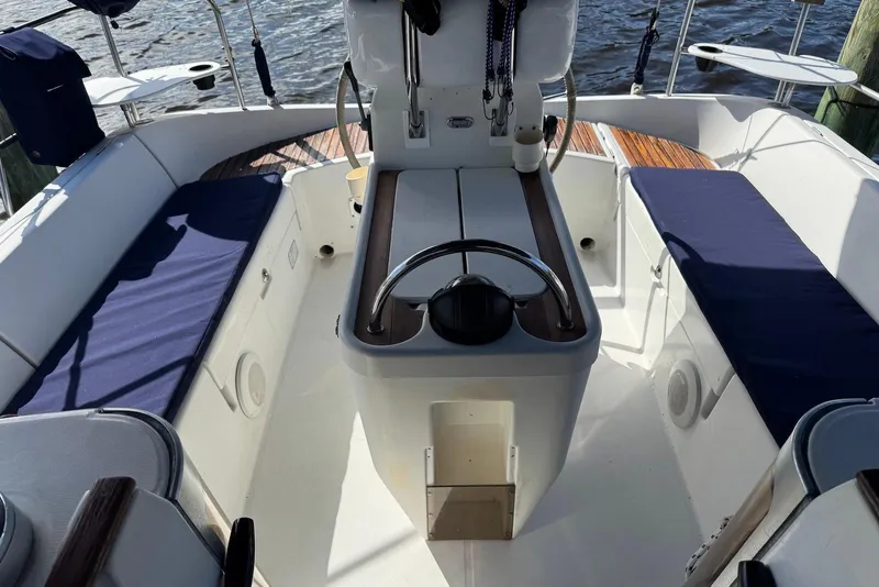 Slide: The Image of Cockpit of 1992 Beneteau Oceanis 370 sailboat with blue cushioned seating and steering wheel. - 12