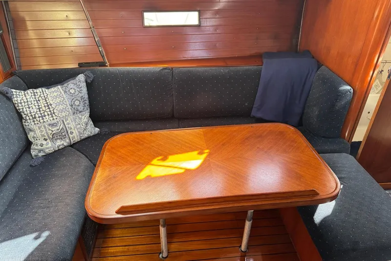 Slide: The Image of Cozy interior of 1992 Beneteau Oceanis 370 with wooden table and cushioned seating. - 25