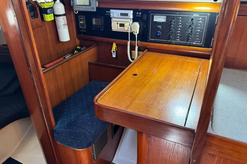 Slide: The Image of Interior of 1992 Beneteau Oceanis 370 sailboat with navigation station and wooden finish. - 30