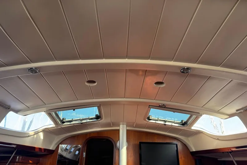 Slide: The Image of Interior view of 1992 Beneteau Oceanis 370 sailboat with skylights and wooden accents. - 35
