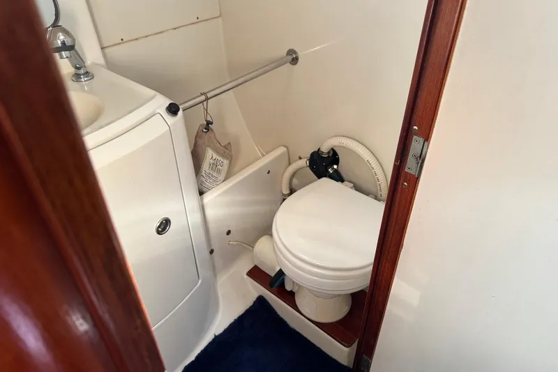 Slide: The Image of Bathroom interior of 1992 Beneteau Oceanis 370 sailboat, featuring compact toilet and sink. - 46