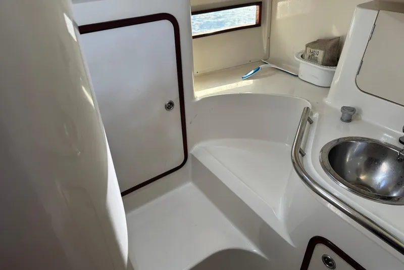 Slide: The Image of Interior of 1992 Beneteau Oceanis 370 sailboat, featuring compact bathroom with sink and storage. - 47