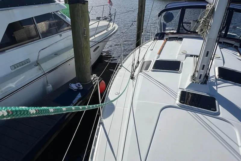 Slide: The Image of 1992 Beneteau Oceanis 370 sailboat docked beside another boat. - 6