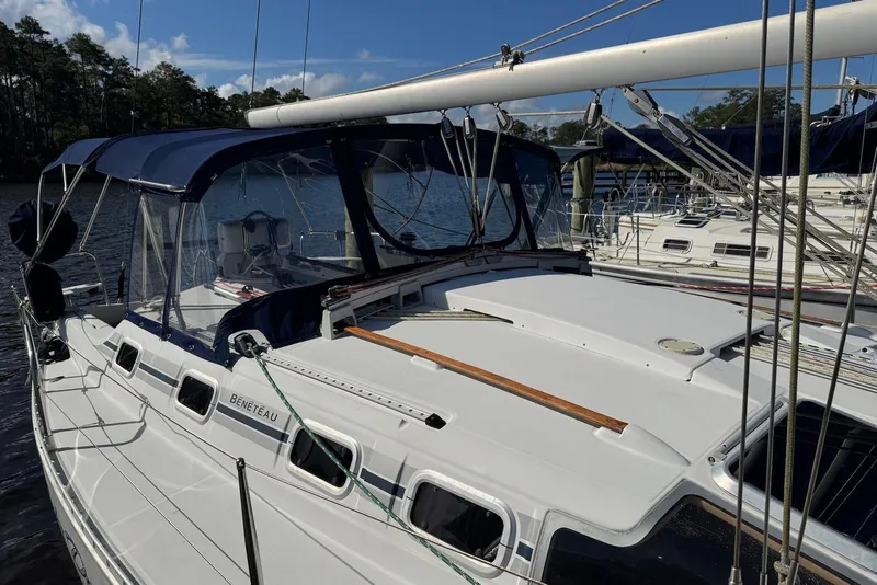 Slide: The Image of 1992 Beneteau Oceanis 370 sailboat docked, featuring a sleek design and blue canopy. - 7