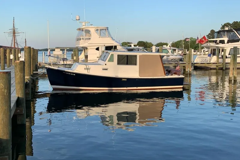 The Image of 1982 Nauset 27 Downeast Cruiser docked in a serene marina setting. - 0