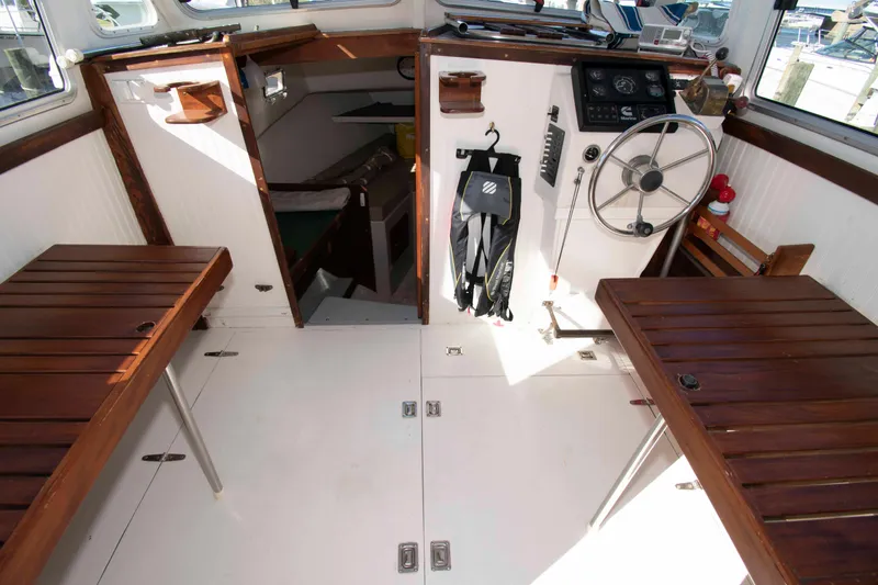 Slide: The Image of Interior of 1982 Nauset 27 Downeast Cruiser with wooden benches and steering wheel. - 15