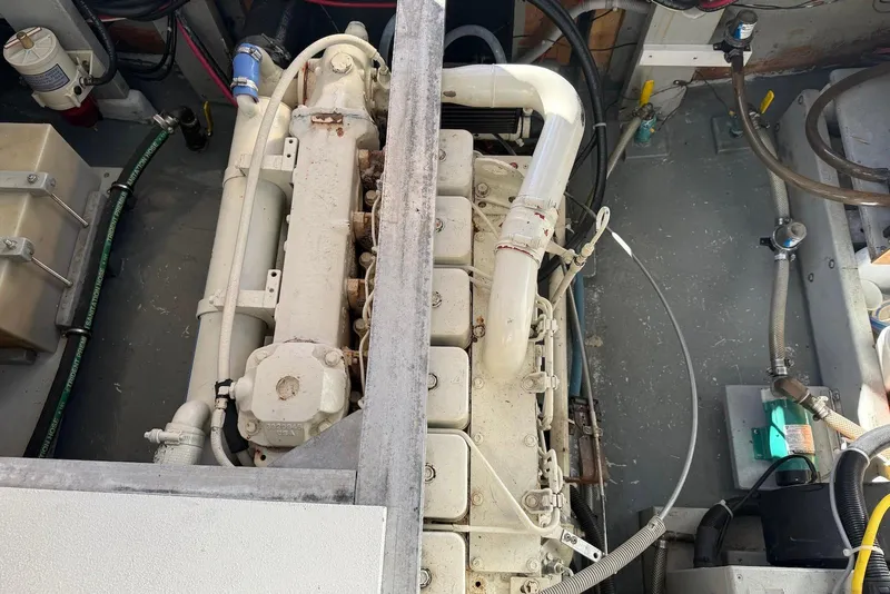 Slide: The Image of Engine compartment of 1982 Nauset 27 Downeast Cruiser, showcasing mechanical components and wiring. - 24