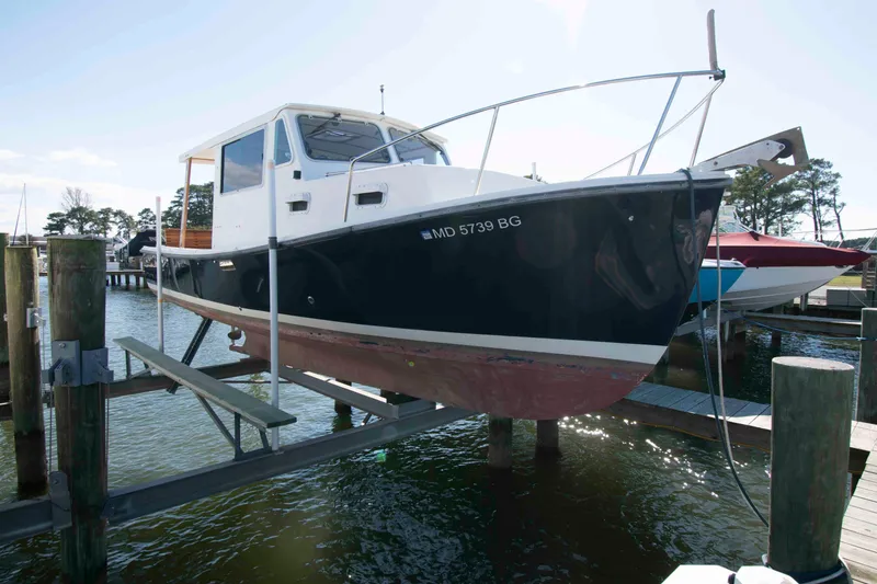 Slide: The Image of 1982 Nauset 27 Downeast Cruiser on boat lift at marina. - 3