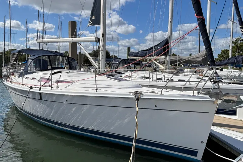 The Image of 2006 Hunter 38 sailboat docked at marina under blue sky. - 0