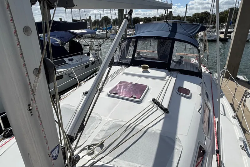 Slide: The Image of Sailboat docked at marina, 2006 Hunter 38 model, with blue canopy and visible rigging. - 11