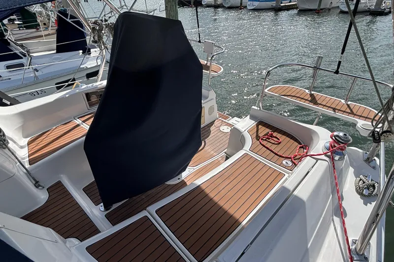 Slide: The Image of 2006 Hunter 38 sailboat cockpit with teak flooring and covered helm, docked at marina. - 14